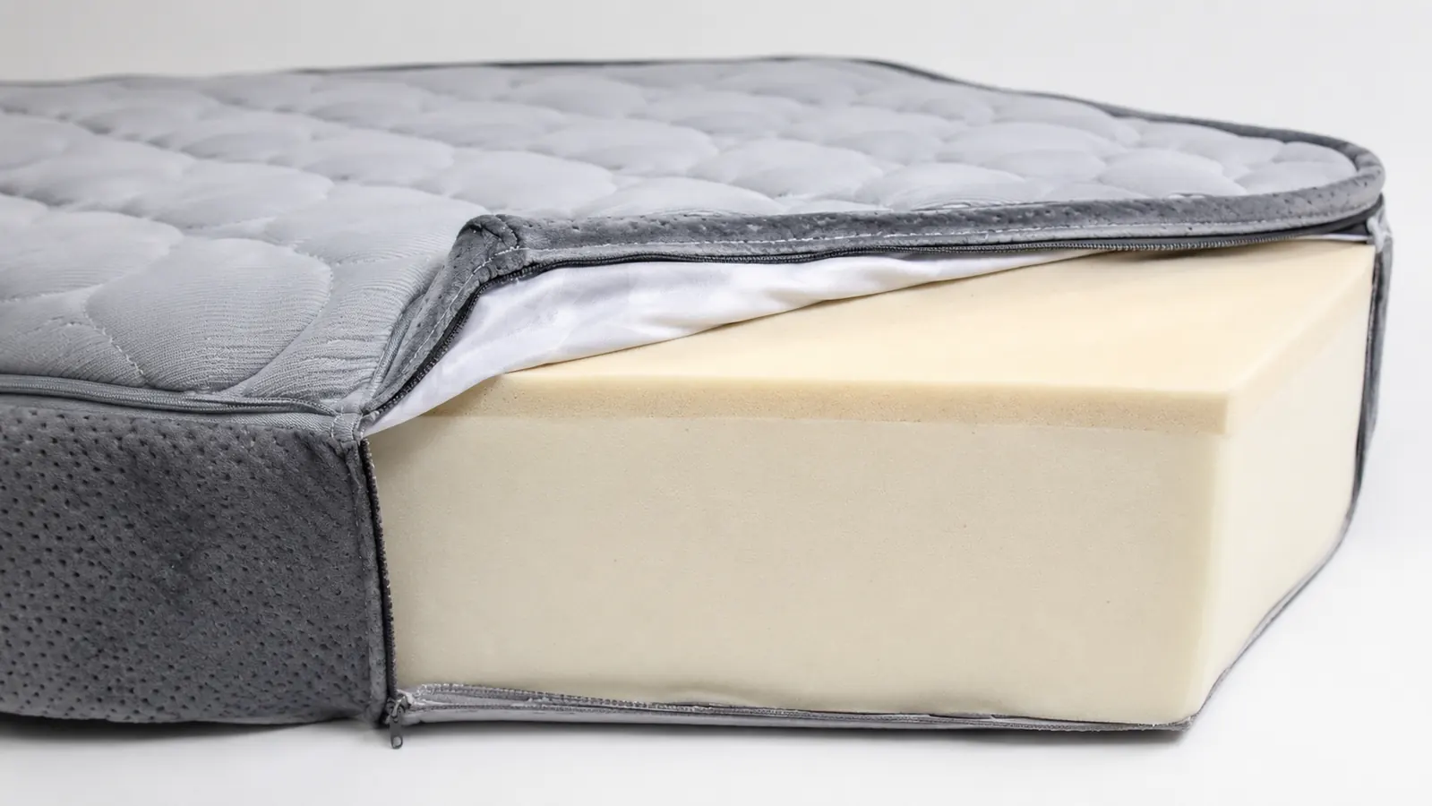 Close-up of memory foam dog bed cross-section showing dense foam base and soft removable cover