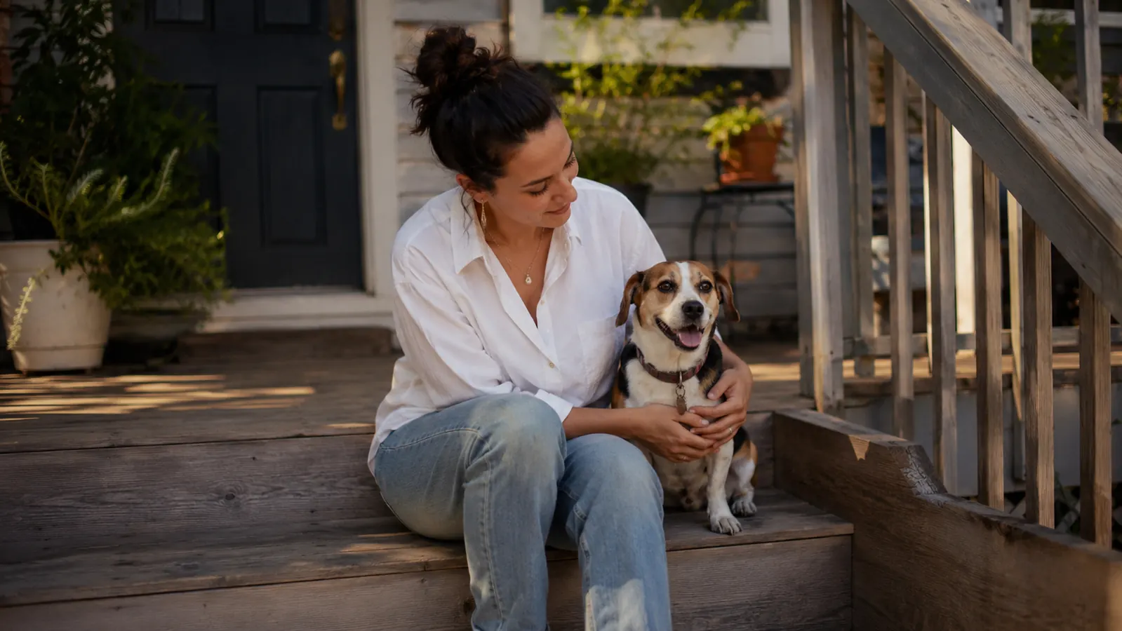 Owner and dog sitting together on front porch steps, both looking calm and relaxed